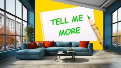 On a bright yellow background, a large wooden pencil and a white sheet of paper with the text TELL ME MORE Wall mural