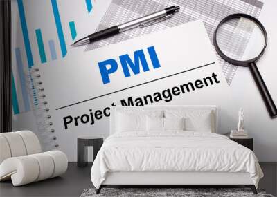 On the table are reports, diagrams, a pen, a magnifying glass and a white notepad with PMI Project Management Institute text. Business concept Wall mural