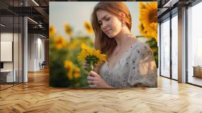 Photo of a beautiful girl in a field with sunflowers. Wall mural