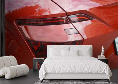 Rear headlight and part of the bumper of a modern red passenger car. Wall mural