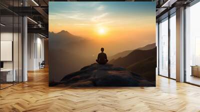 A peaceful photo capturing a person meditating on a mountaintop at sunrise, the tranquil setting and connection with nature representing the journey of self-discovery. Wall mural