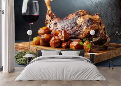 Cooked leg of lamb and new potatoes. On a gray background. Wall mural