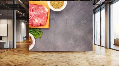 Raw fresh marble meat steak on a cutting Board and seasonings on a dark marble background, top view. fresh greens with beef Wall mural