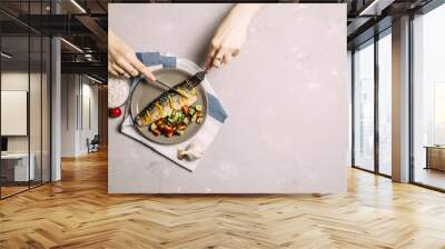 Baked mackerel with spices and herbs on a plate, fish still life on a dark background, assortment of peppers, garlic, lemon, cherry tomatoes, dill Wall mural