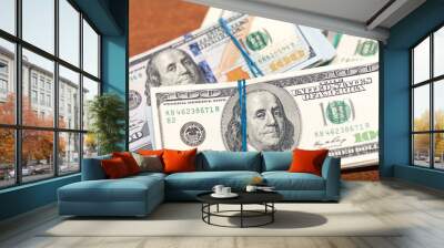 Many hundred dollar bills on wooden table background texture. bundles of money scattered on the office desk. wealth and income concept Wall mural