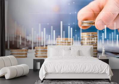 man stacks coins in columns, double exposure with graph and diagram. concept of counting savings Wall mural