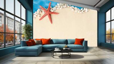 small seashells and starfish in the form of a coastline on a summer background of sand and sea Wall mural