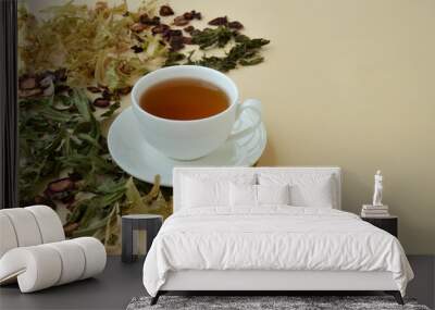 Herbal tea in a white cup for beauty and health, dried herbs, linden flowers and strawberries lie around. Wall mural