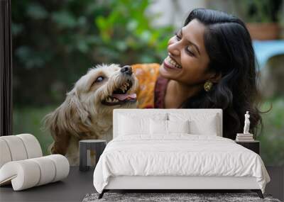 A woman is sitting on the grass with a dog Wall mural