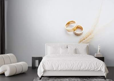 Gold wedding rings are decorated with wheat germ, with copy space. The concept of wedding backgrounds for texts. Wall mural