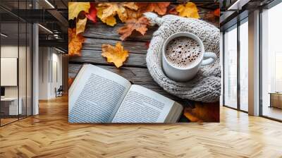 A warm background with a knit sweater, a book, and a mug of hot cocoa placed on a weathered wooden table Wall mural