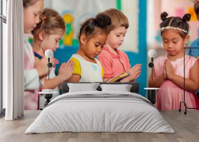 a  of children in a Sunday school class, each holding a Bible and bowing their heads in prayer, Backgrounds, People, Praying, Heaven, Religion, Bible, with copy space Wall mural