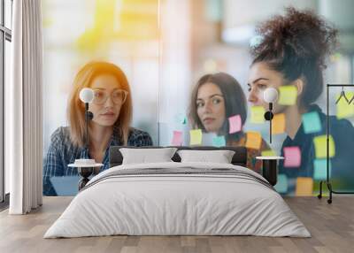 Two creative professionals collaborating at a brainstorming session, their focus on a glass wall filled with colorful sticky notes. The soft glow of natural light and a subtle boke Wall mural