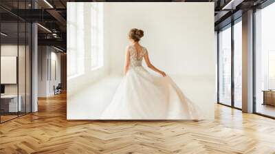 bride in white dress. young woman in wedding dress in white room. 
 Wall mural