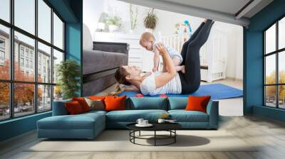 Beautiful mother with her baby doing physical exercises on fitness mat Wall mural