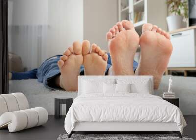 Closeup of child and adult feet lying on carpet and moving. Wall mural