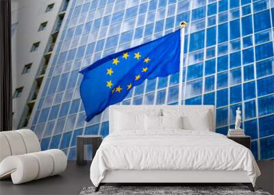 Image of EU flag fluttering on wind against high business office building made of concerete and glass. Concept of ecenomics, development, government and politics Wall mural