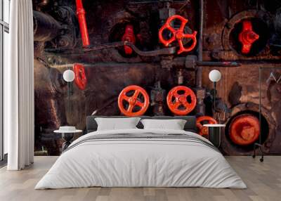 Toned photo of old rusty steam pipes and red valves on steam boiler of old locomotive Wall mural