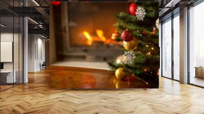 Wooden table in front of decorated fireplace and Christmas tree. Place for text. Suitable for Christmas background. Wall mural