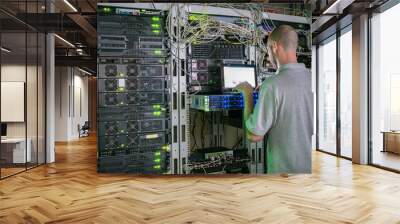 The system administrator works in the server room of the data center. A programmer with a laptop is in the room with computer equipment. The concept of information technology. Wall mural