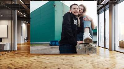 young fashionable in love beautiful couple shopping and having fun near the supermarket ride on a trolley Wall mural