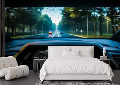 Dashboard view of car driving on road with trees in the background. Wall mural