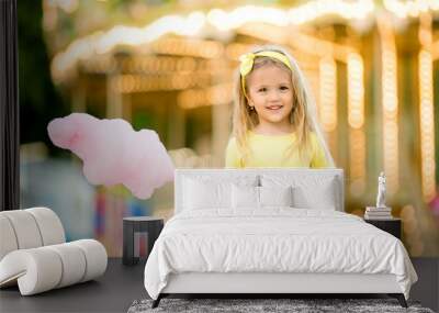 happy child girl with cotton candy at an amusement Park. the concept of the international children's day. happy healthy child in the summer Wall mural