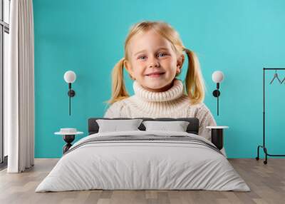 little blonde girl smiling in white knitted sweater on blue background Wall mural