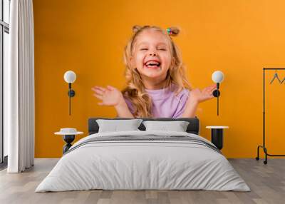 portrait of a happy child girl isolate on a yellow background, space for text Wall mural