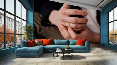 A man's hand with a gold wedding ring in close-up Wall mural