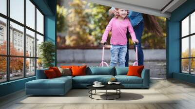 Smiling happy little girl walking on crutches, mother helps to go Wall mural