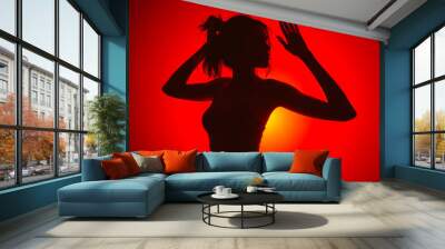 Silhouette of a woman posing against a red background. Wall mural