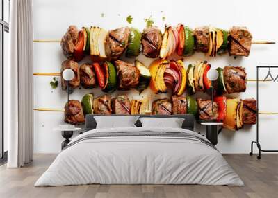 Two skewers of meat with vegetables on them. The vegetables are peppers and onions. The skewers are on a white background Wall mural