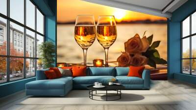 Two wine glasses filled with champagne sit on a table by the water. The sun is setting, casting a warm glow over the scene. Scene is relaxed and enjoyable Wall mural