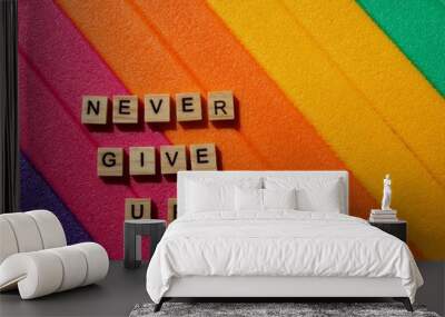 Words written on wooden blocks. Colorful background. Never give up. Motivational message. Words and phrases. Never give up writing. Positive background. Colors Wall mural