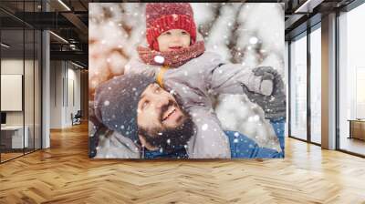 happy father and baby son having fun under sunny winter snow, holiday season. Wall mural