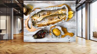 Fresh baked fish sea bass (Dicentrarchus labrax) on a light wooden background Wall mural