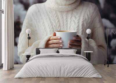 closeup a woman's hands in a white knitted sweater holding a cup of coffee Wall mural