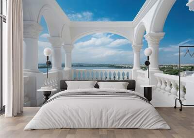 View of a beautiful white balcony with columned arches and balustrade with a sea harbor and cityscape under a cloudy blue sky in the background Wall mural