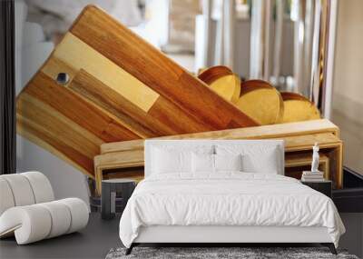 .wooden kitchen boards stacked in the sink. Kitchen wooden utensils on a light background Wall mural