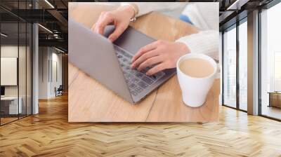 Woman is typing on keyboard of laptop or notebook at home freelance, check electronic mail, get some information for shopping online or operate of banking on web. Cup of coffee. Wall mural