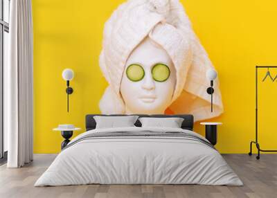 Antique female statue's head with a white towel after a shower and cucumber slices on her eyes isolated on a yellow background. 3d contemporary art. Modern design Wall mural