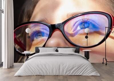 Close up of woman's eyes with red and black female glasses for working at a computer with a blue filter lenses. Anti blue light and rays. Eye protection Wall mural