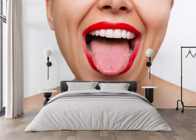 Cropped shot of young caucasian woman showing tongue with her mouth wide open isolated on a white background. Female lips with red lipstick. Teeth whitening. Oral hygiene, dental health care Wall mural