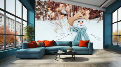  Snowman in a blue knitted scarf and a brown cowboy hat copyspace. Wall mural