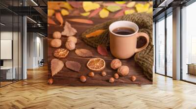 Autumn, fall leaves, hot cup of coffee and warm knitted scarf on wooden table, copy space. Seasonal, morning coffee, sunday rest and home and coziness concept. Wall mural