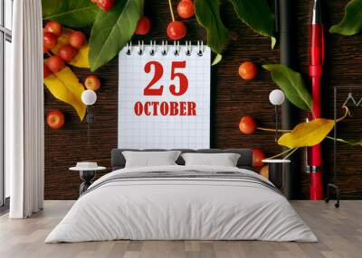 calendar date on wooden dark desktop background with autumn leaves and small apples. October 25 is the twenty-fifth day of the month Wall mural