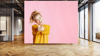 close-up portrait of cheerful young caucasian female with curly blonde hair, in yellow sweater poses Wall mural