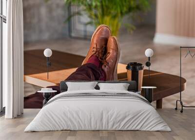 Close up of a man holding his legs on a table Wall mural