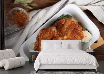 Raw guinea fowl smeared with spices with paprika lies on a white dish for baking with garlic and rosemary Wall mural